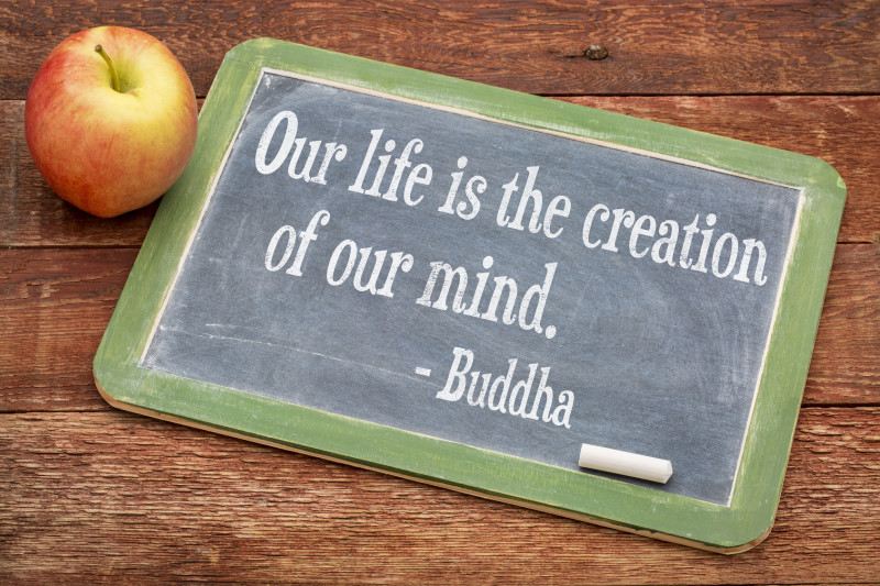 Our life is creation of our mind - Buddha quote  on a slate blackboard against red barn wood